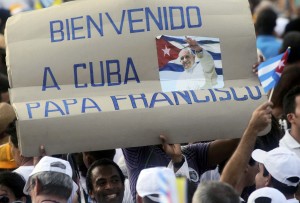 A man holds up a sign welcoming Pope Francis at the first mass of his visit to Cuba in Havana's Revolution Square, September 20, 2015. The sign reads, "Welcome to Cuba Pope Francis." REUTERS/Stringer
